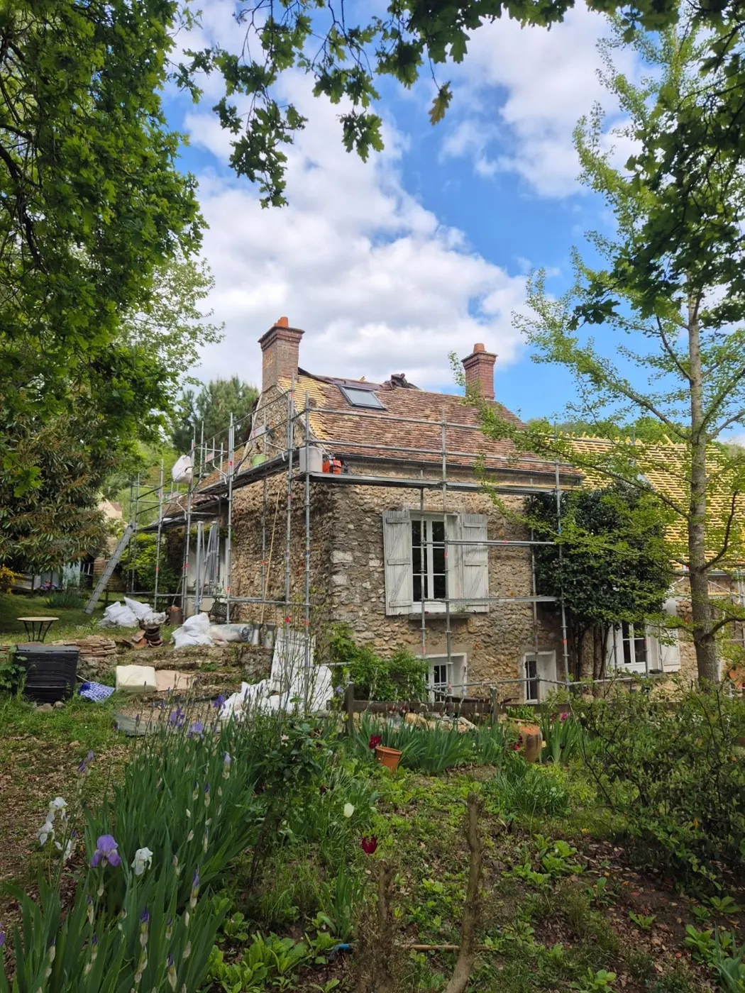 Toiture en tuiles rénovée par Les Couvreurs Versaillais sur une maison en pierre